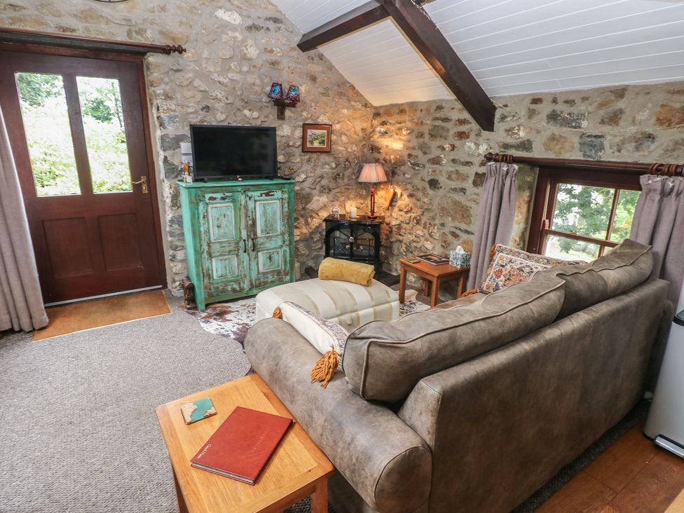 A living room with a sofa and television at Coach House in Haverfordwest near Broad Haven