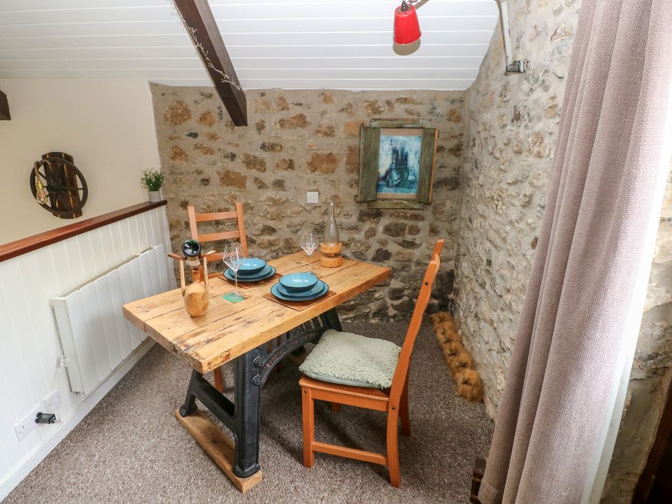 A dining room with a wooden table and chairs at Coach House Haverfordwest near Broad Haven