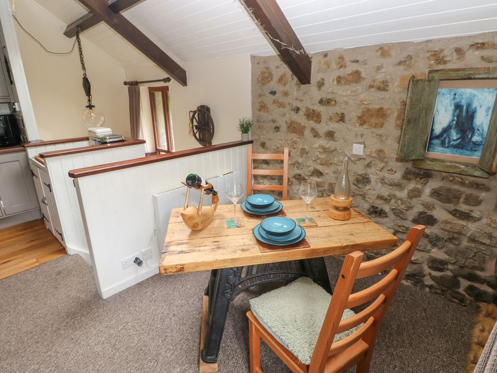 A dining room with a wooden table and chairs at Coach House in Haverfordwest near Broad Haven