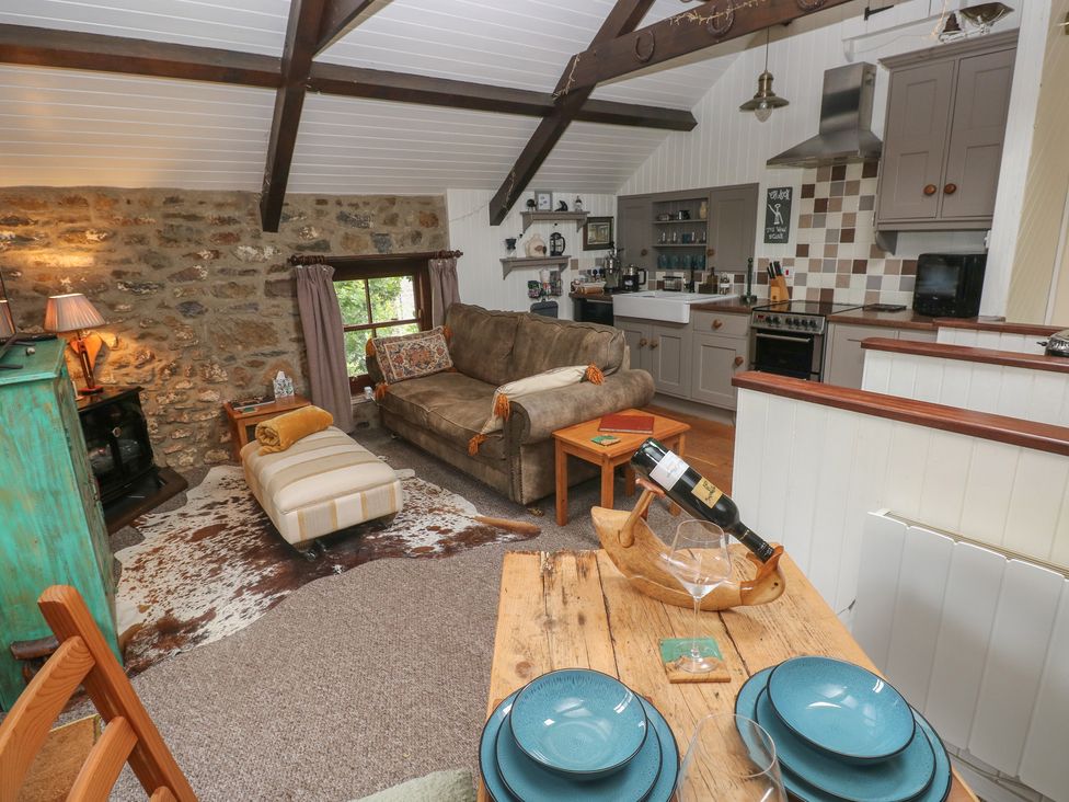 A living room with a sofa and kitchen unit at Coach House Haverfordwest near Broad Haven