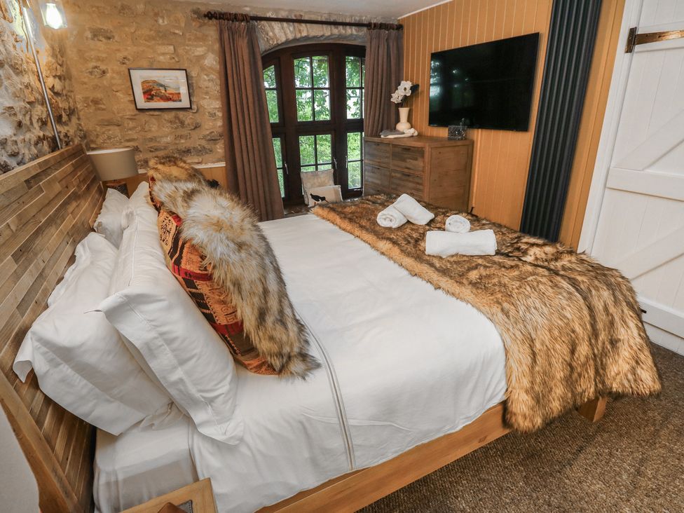 A bedroom with a bed and TV at Coach House Haverfordwest near Broad Haven