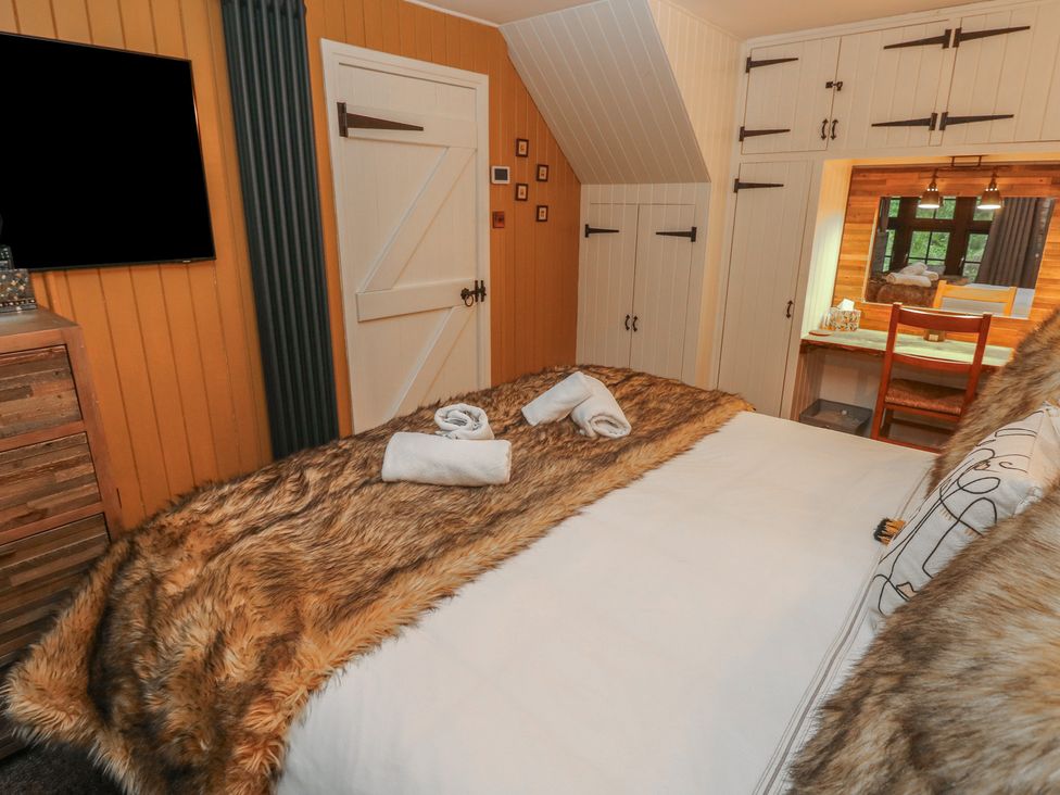 A bedroom with a bed and television at Coach House, Haverfordwest near Broad Haven