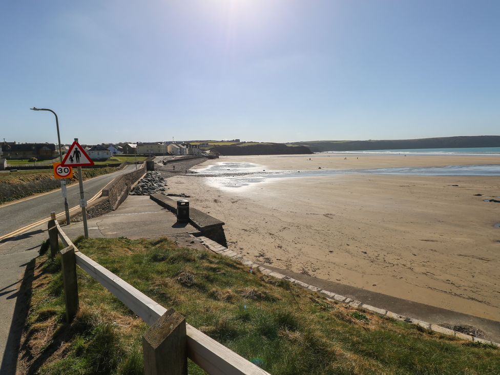 A beach area with a road and houses near the sea at Coach House Haverfordwest near Broad Haven