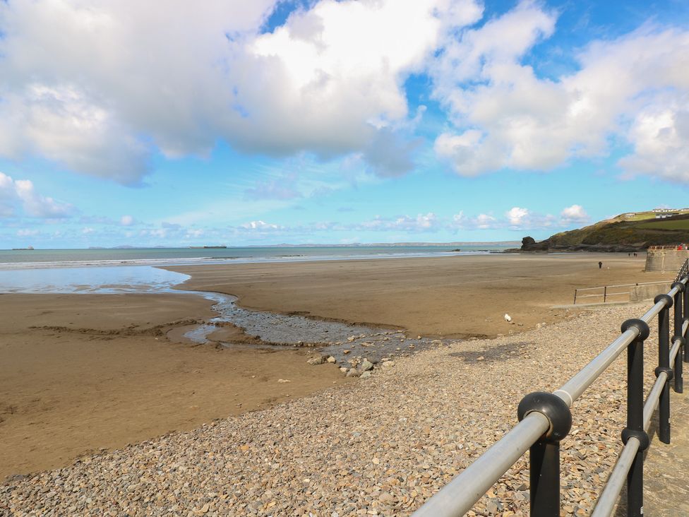 A beach with a stream and rocks at Coach House Haverfordwest near Broad Haven