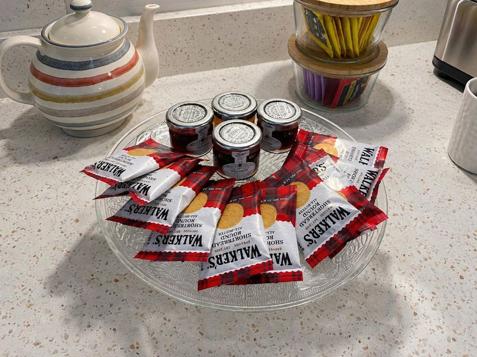 A kitchen counter with a teapot, jam jars, and shortbread packets at Kalipé in Kenmore