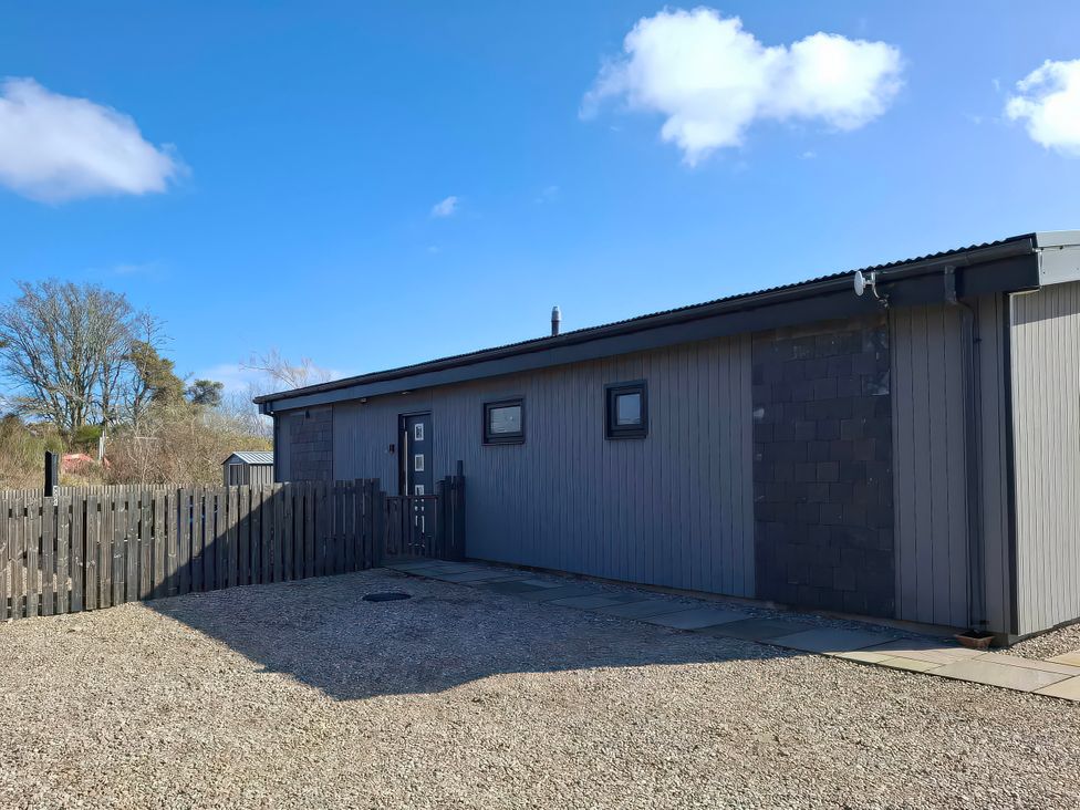 A building with a fence and pathway at Red Squirrel in Dornoch