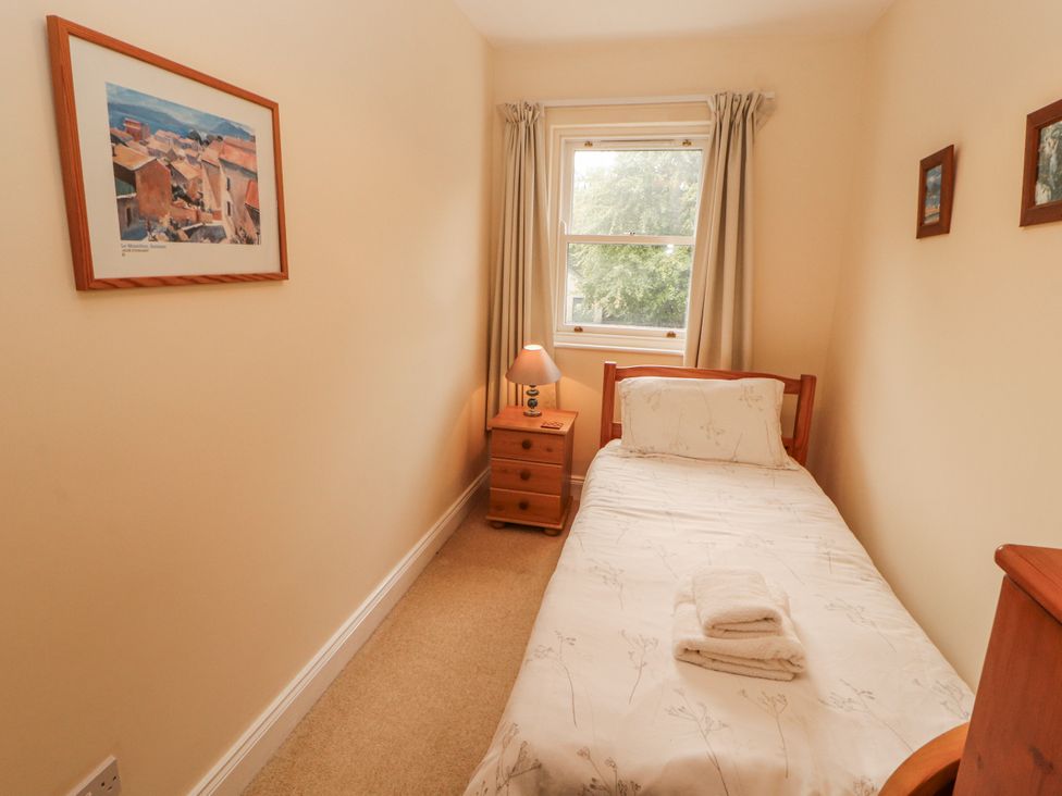 A bedroom with a single bed and a lamp on a nightstand at Flat 17 in Keswick