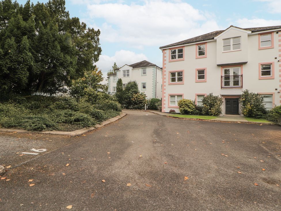 A parking lot with buildings and greenery at Flat 17 in Keswick