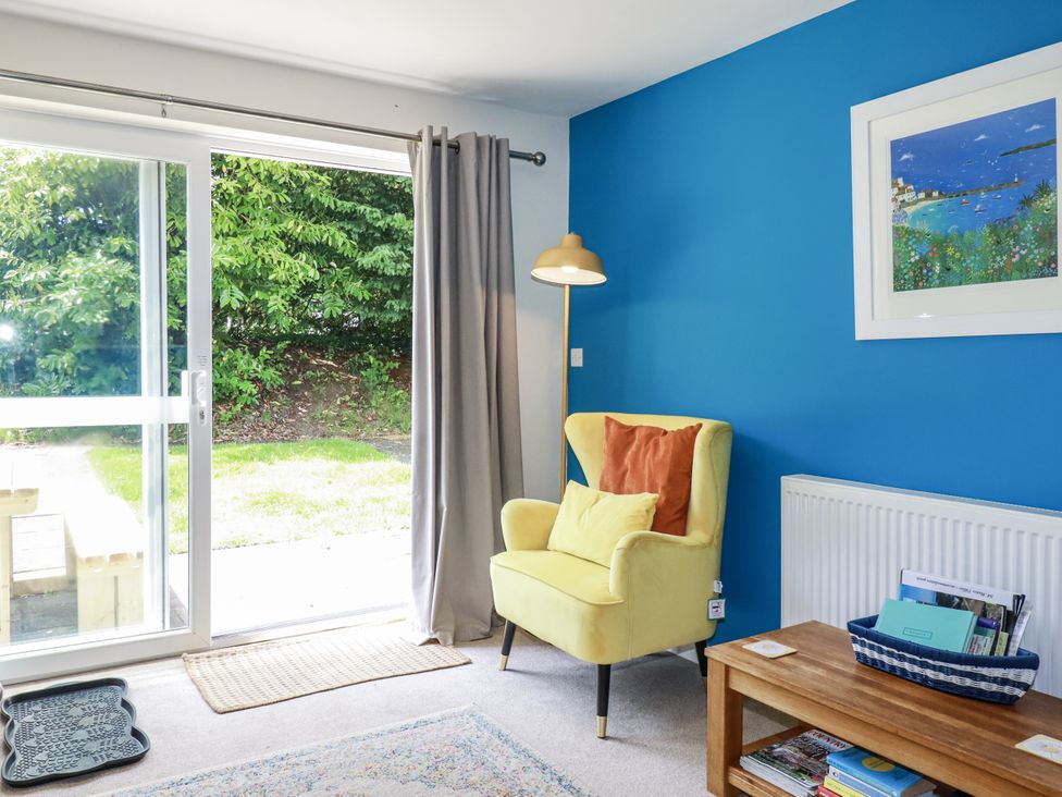 A living room with a yellow chair and a sliding door at 64 St Columb Road