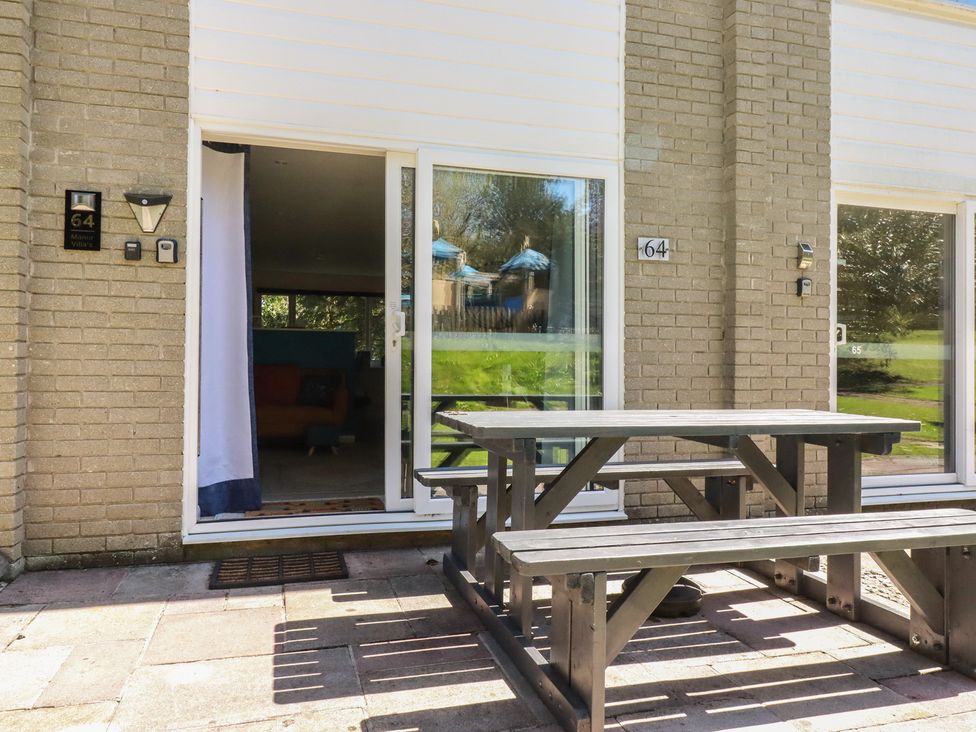 An outdoor area with a table and bench at 64 St Columb Nr Newquay