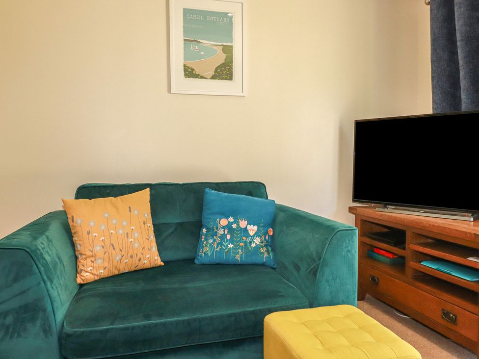 A living room with a green sofa and a television at 64 St Columb Nr Newquay