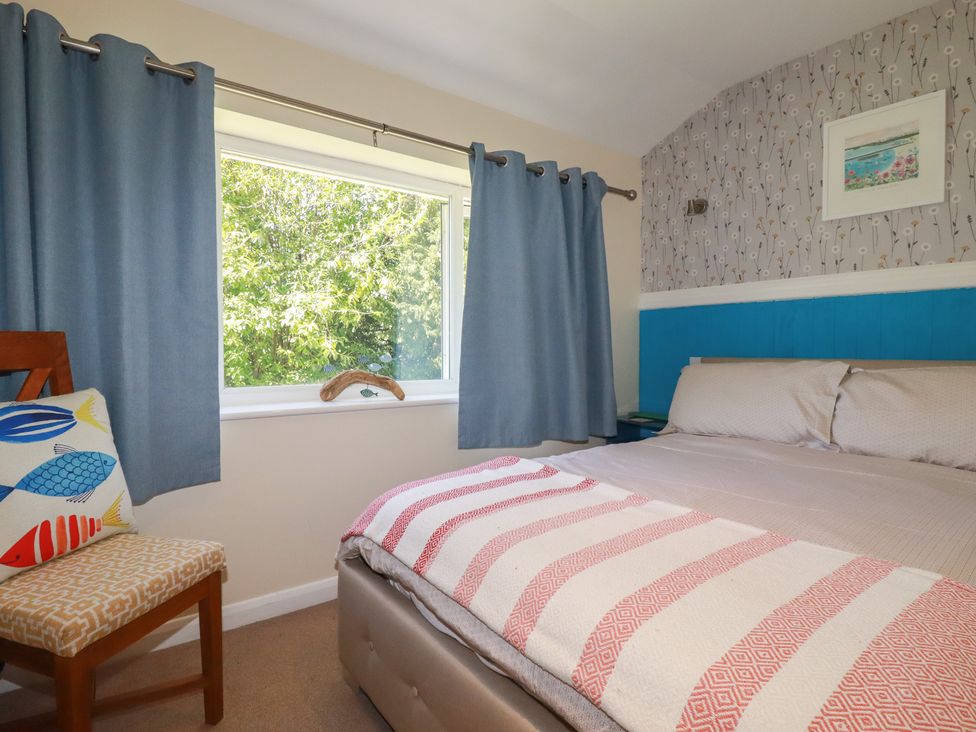 A bedroom with a bed and chair at 64 St Columb Nr Newquay