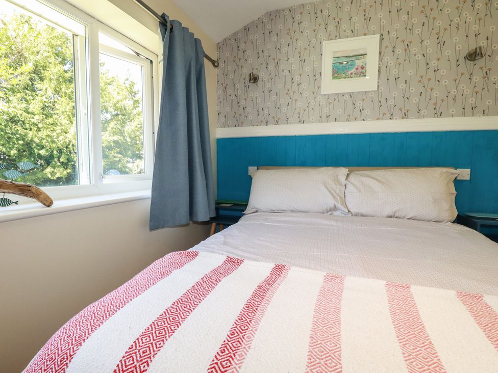A bedroom with a bed and windows at 64 St Columb Nr Newquay