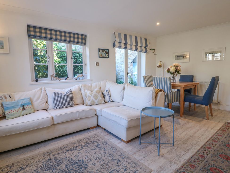 A living room with a sofa and dining table at November Cottage in Dittisham