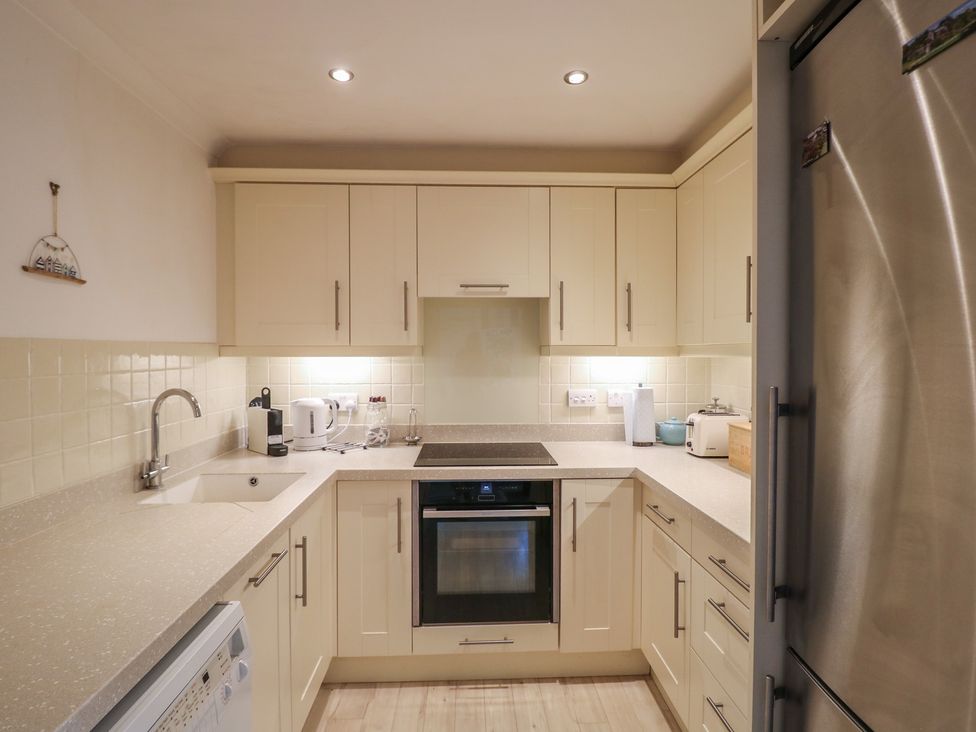 A kitchen with cupboards and appliances at November Cottage in Dittisham