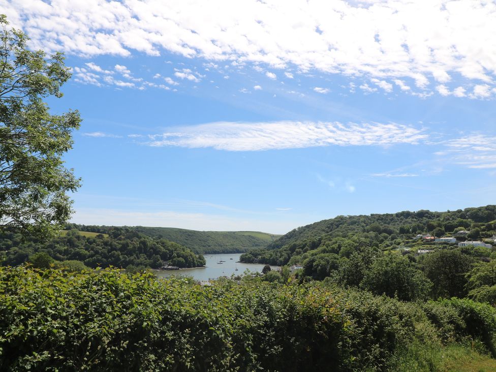 A view of a river surrounded by hills and trees at November Cottage in Dittisham