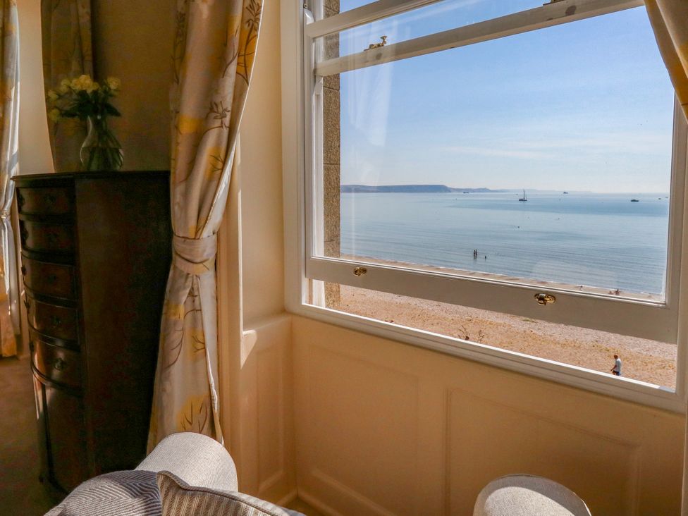 A view of the beach and sea from a window at 123 On The Sea – Victoria’s Place in Weymouth