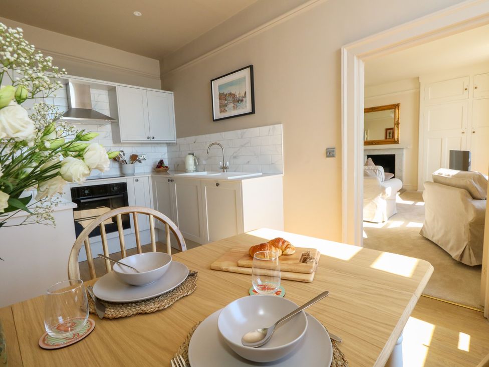 A kitchen with dining table and chairs at 123 On The Sea – Victoria’s Place Weymouth