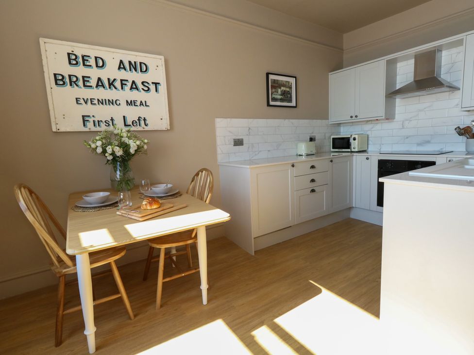 A dining area with a table and chairs in a kitchen at 123 On The Sea – Victoria’s Place Weymouth