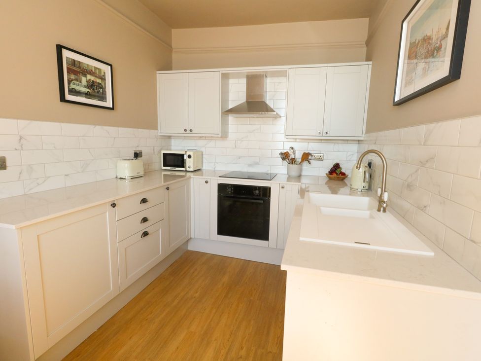 A kitchen with cabinets and appliances at 123 On The Sea – Victoria’s Place, Weymouth