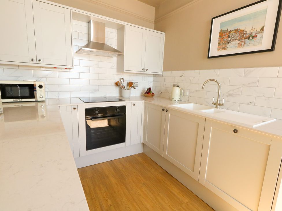 A kitchen with cabinets, sink, oven and microwave at 123 On The Sea – Victoria’s Place, Weymouth