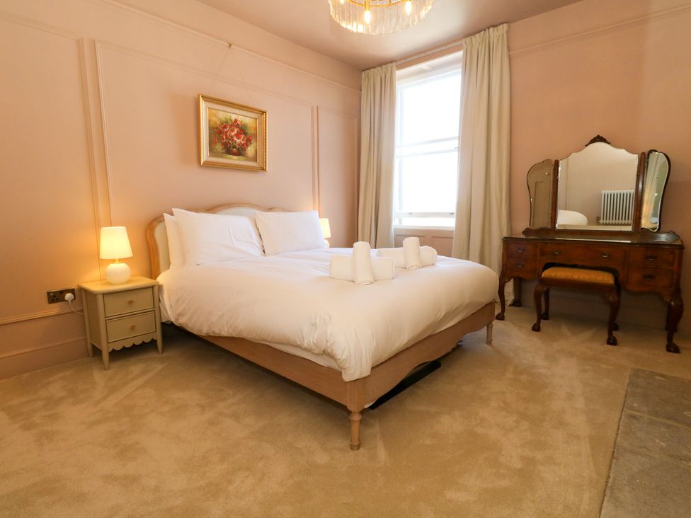 A bedroom with a bed and a dressing table at 123 On The Sea – Victoria’s Place, Weymouth