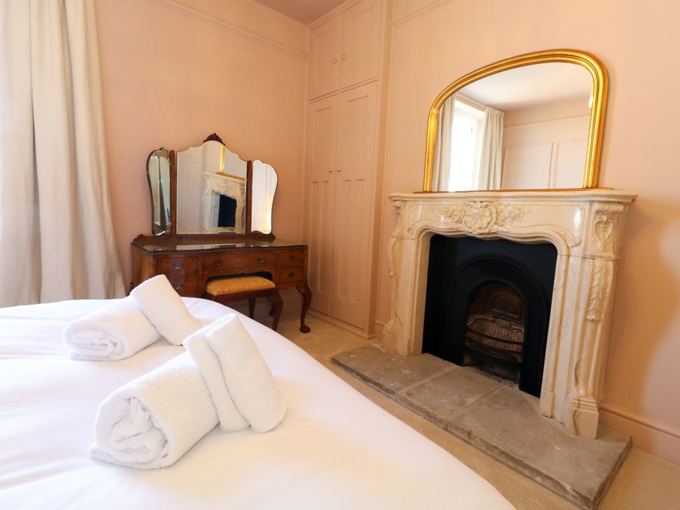 A bedroom with a bed and a mirror at 123 On The Sea – Victoria’s Place Weymouth