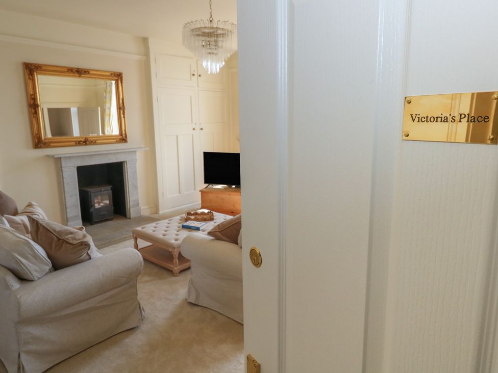 A living room with a fireplace and television at Victoria’s Place in Weymouth