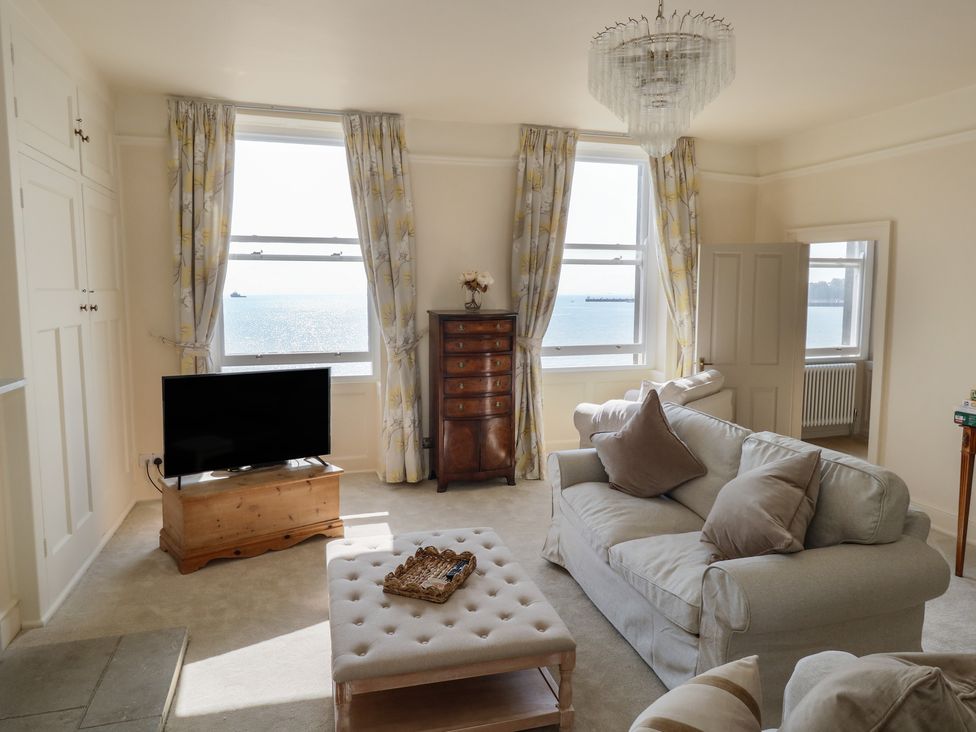 A living room with a television and a chest of drawers at 123 On The Sea – Victoria’s Place in Weymouth