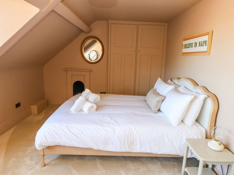 A bedroom with a bed and wardrobe at 123 On The Sea – The Eaves in Weymouth