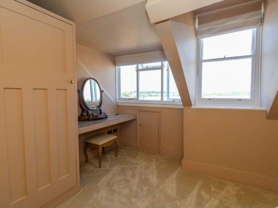 A bedroom with a dressing table and mirror at 123 On The Sea – The Eaves, Weymouth