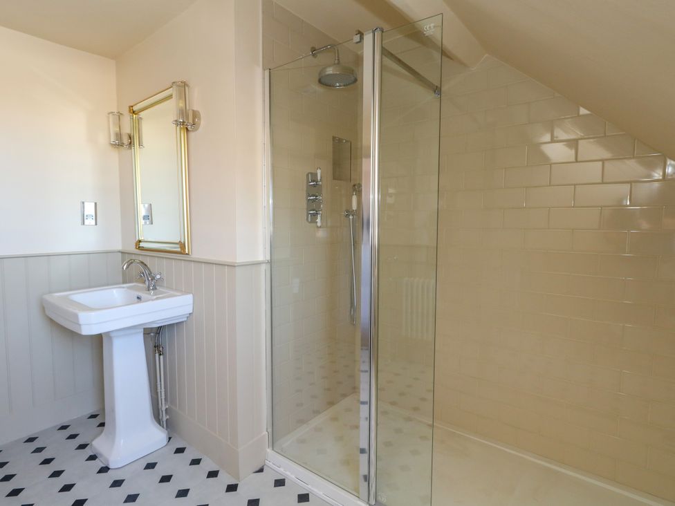 A bathroom with a shower and wash basin at 123 On The Sea – The Eaves, Weymouth