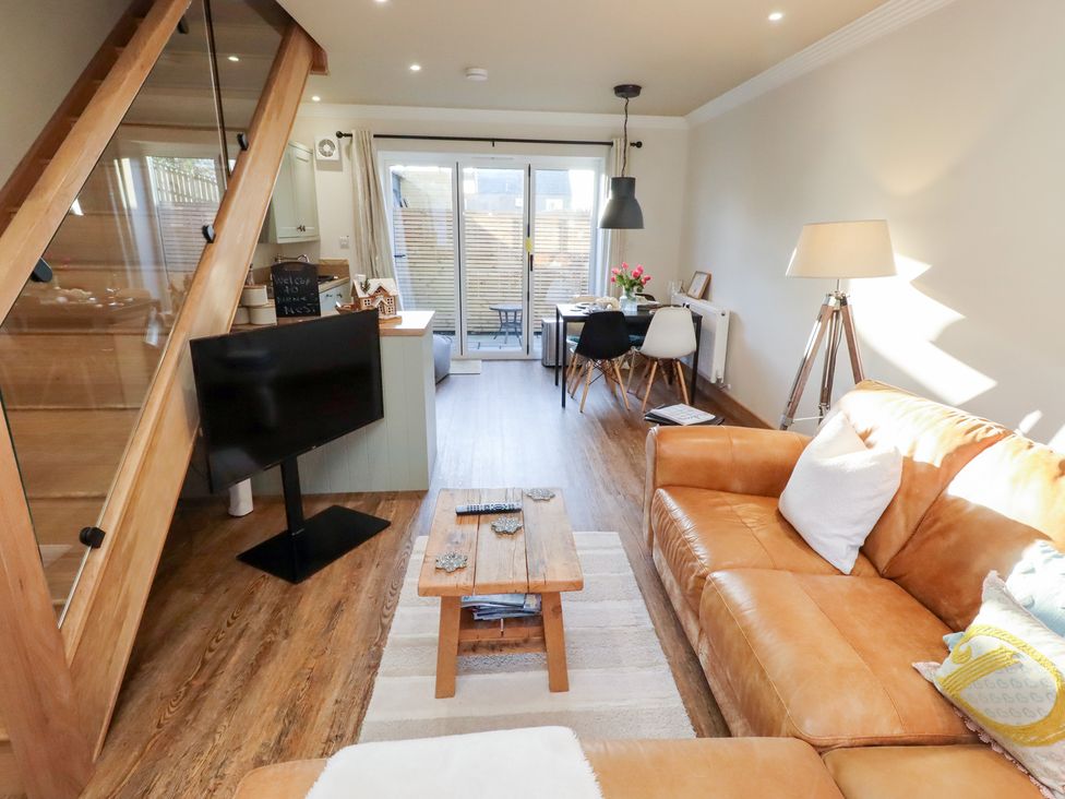 A living room with a sofa and television at Nene's Nest in Alnwick