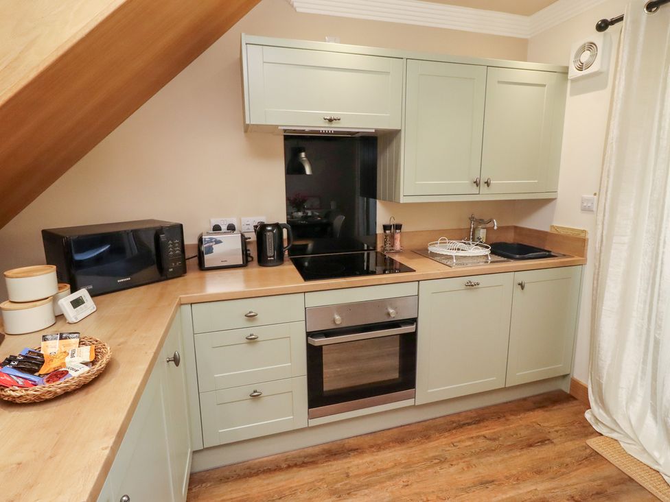 A kitchen with basic appliances and cabinets at Nene's Nest in Alnwick