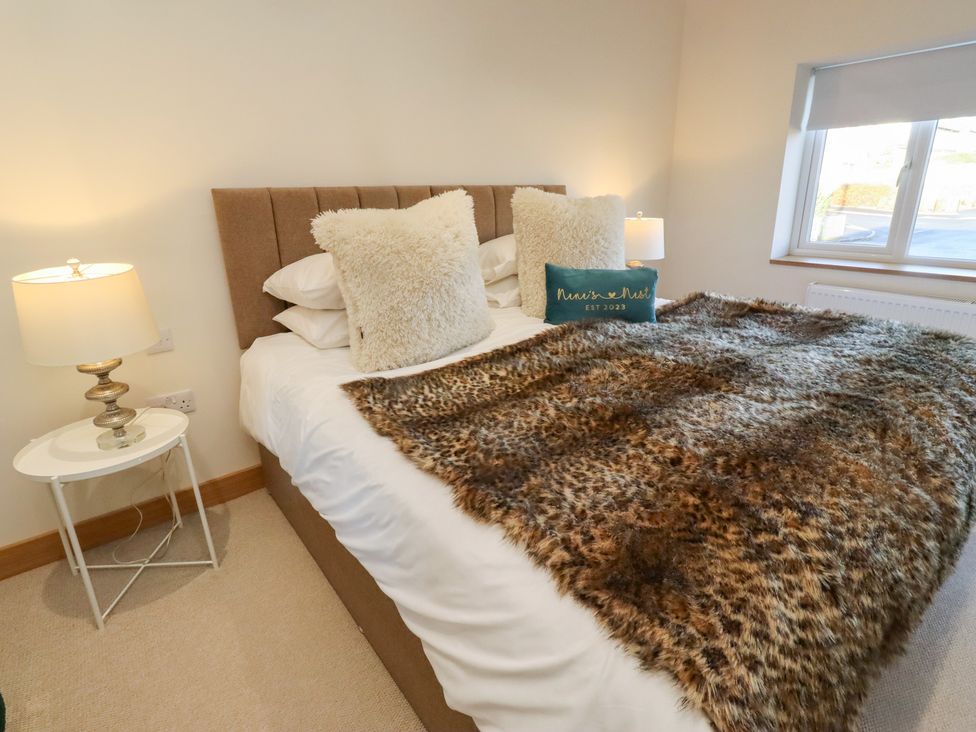 A bedroom with a bed and decorative pillows at Nene's Nest in Alnwick