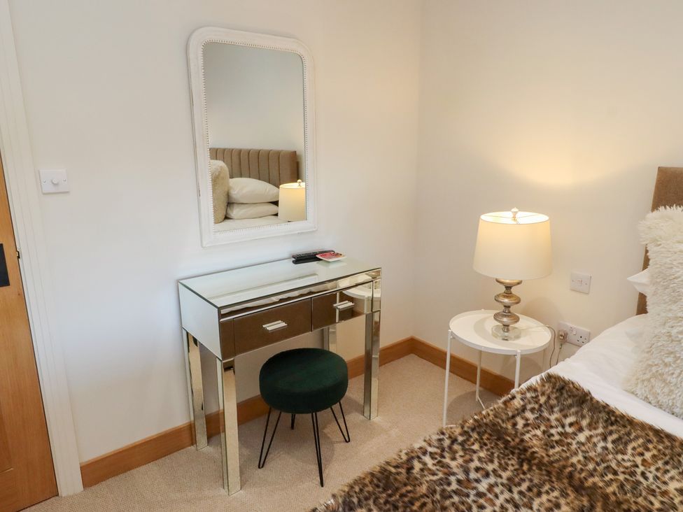 A bedroom with a dressing table and a lamp at Nene's Nest in Alnwick
