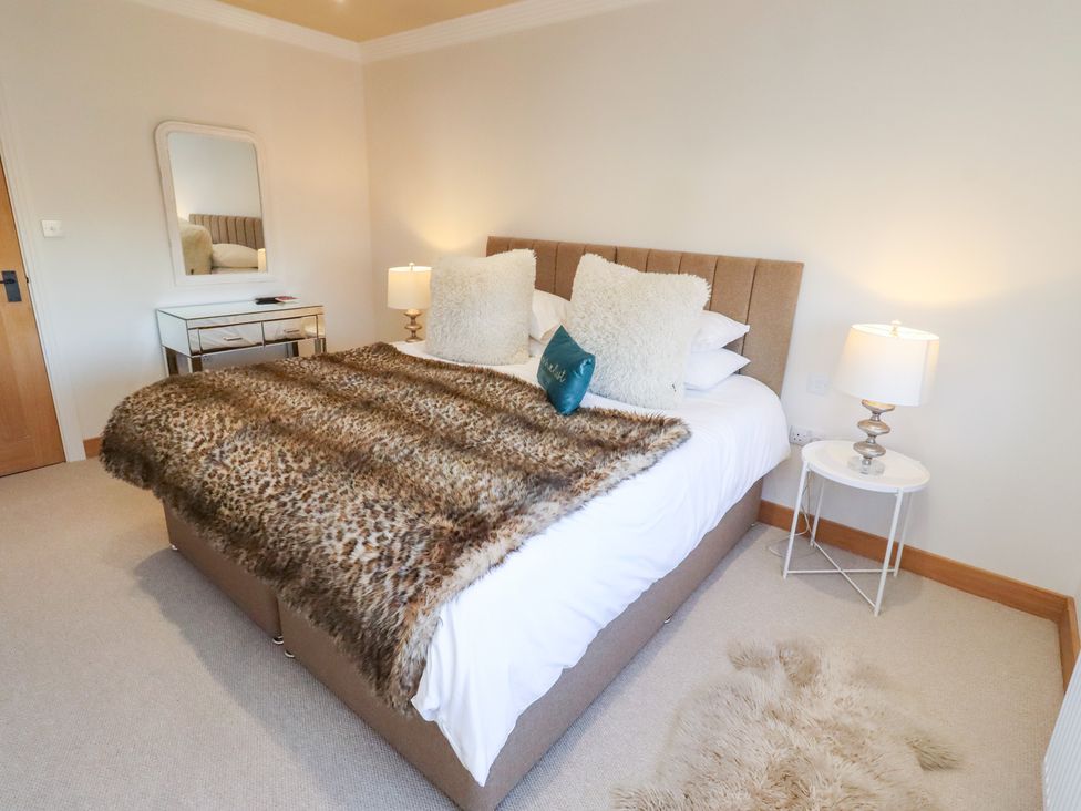 A bedroom with a bed and bedside tables at Nene's Nest in Alnwick