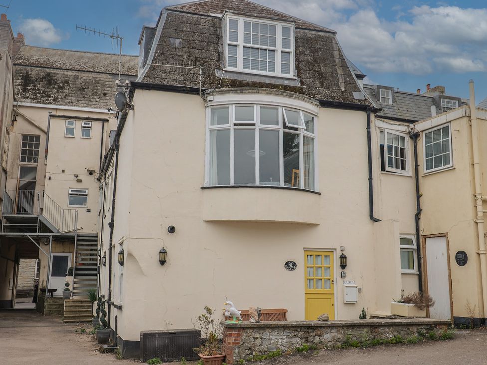 An outdoor view of a house with a yellow door at Jasper in Lyme Regis