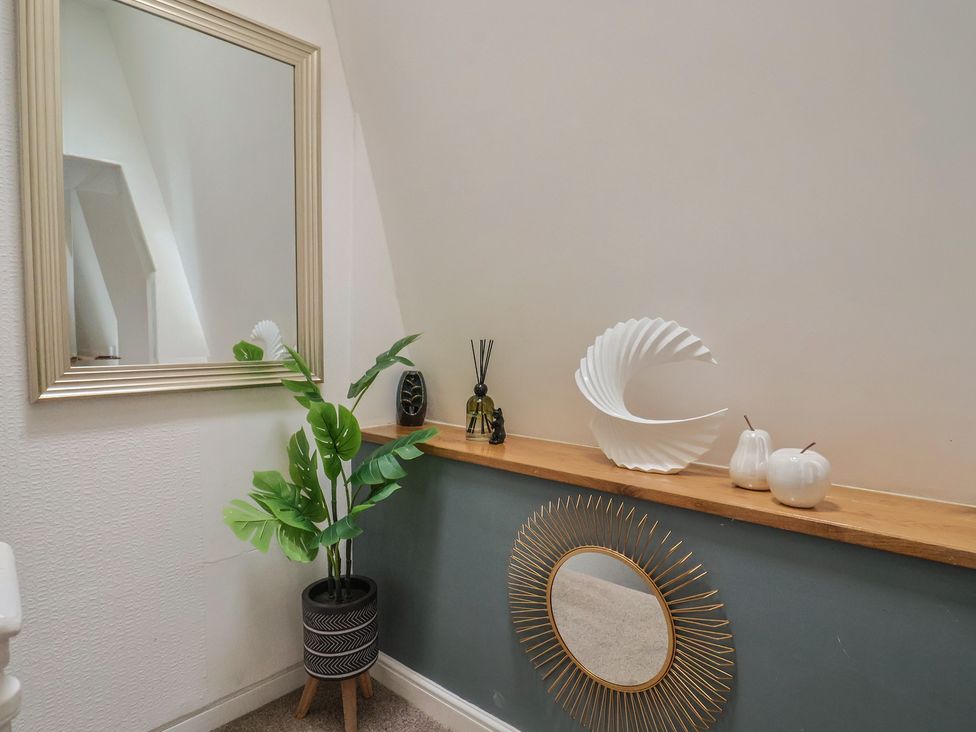 A hallway with a mirror and decorative items at Jasper in Lyme Regis