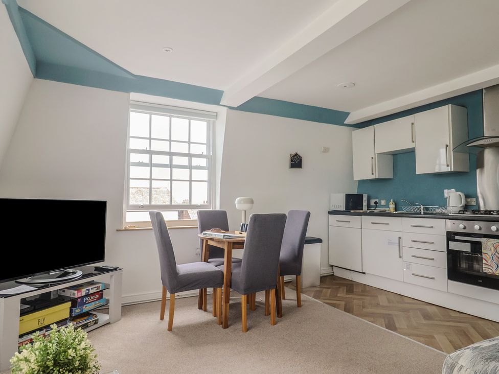A kitchen with dining table and chairs at Jasper in Lyme Regis