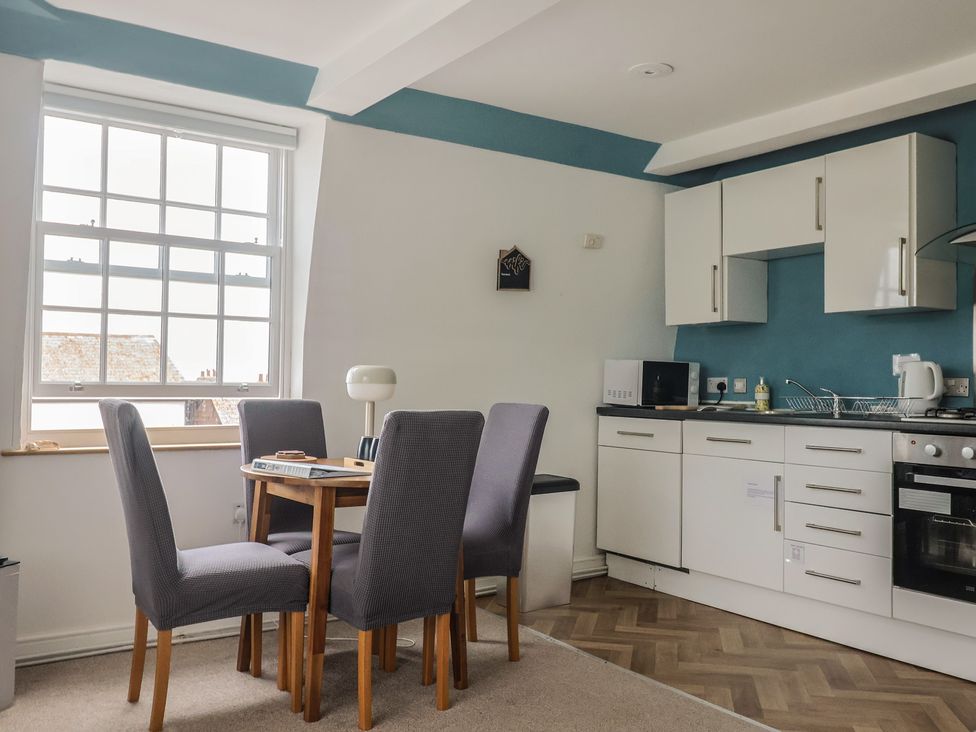 A kitchen with table and chairs at Jasper in Lyme Regis