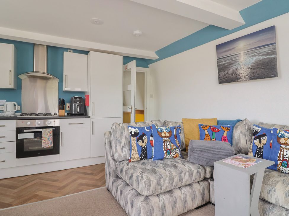 A living room with sofa and kitchen in Jasper Lyme Regis