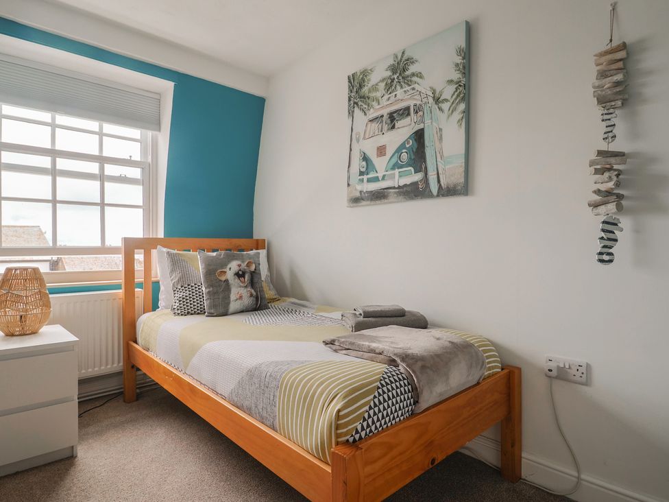 A bedroom with a bed and nightstand at Jasper in Lyme Regis