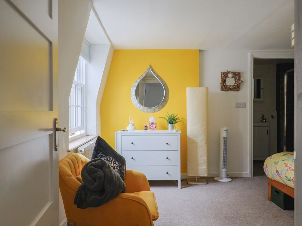 A bedroom with a mirror and dresser at Jasper in Lyme Regis