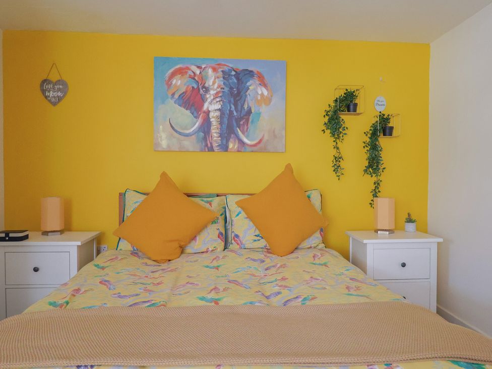 A bedroom with a bed and wall art at Jasper in Lyme Regis