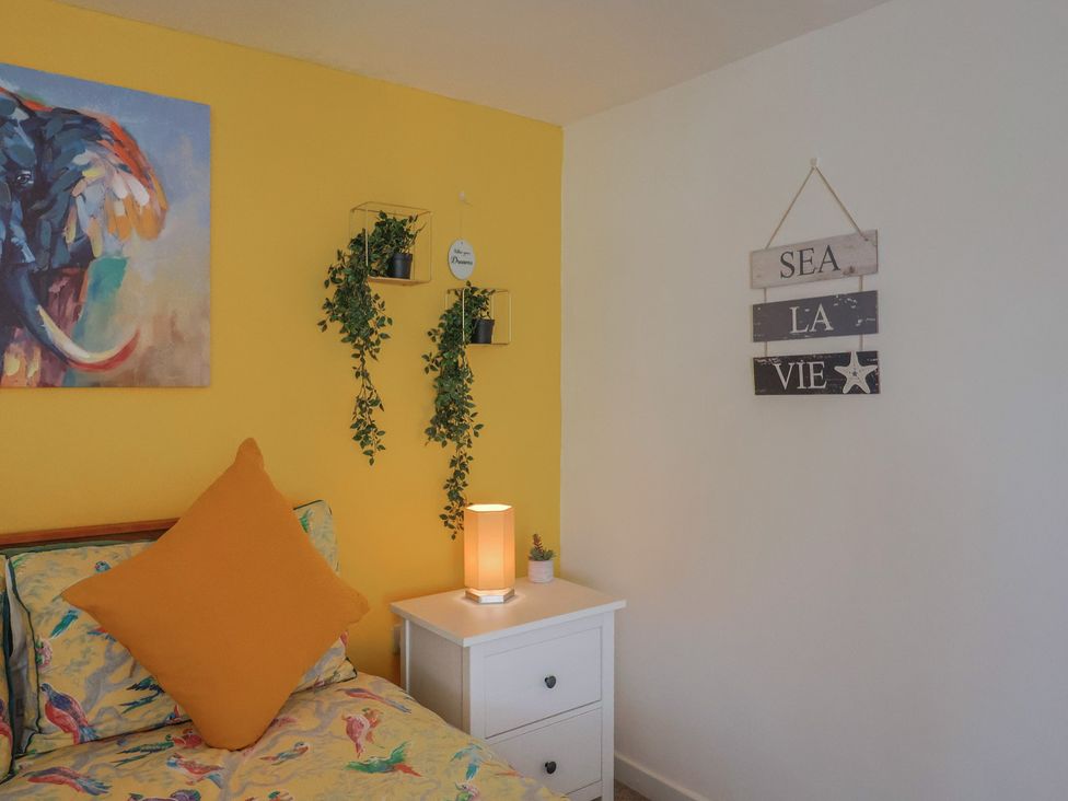 A bedroom with a bed and nightstand at Jasper in Lyme Regis