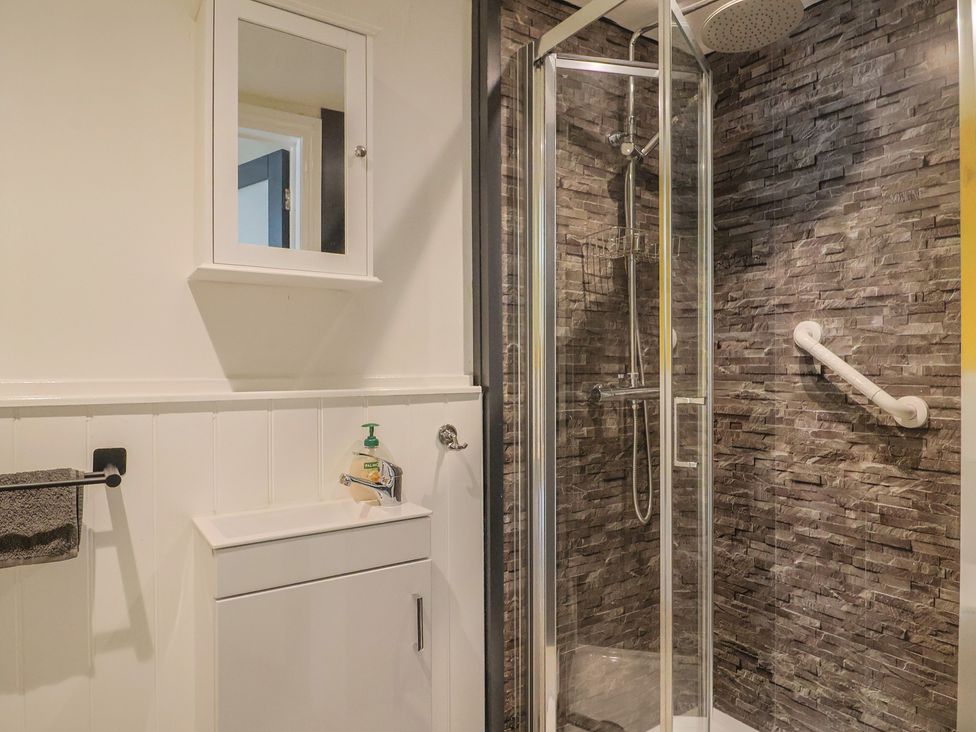 A bathroom featuring a shower, sink, and mirror at Jasper in Lyme Regis
