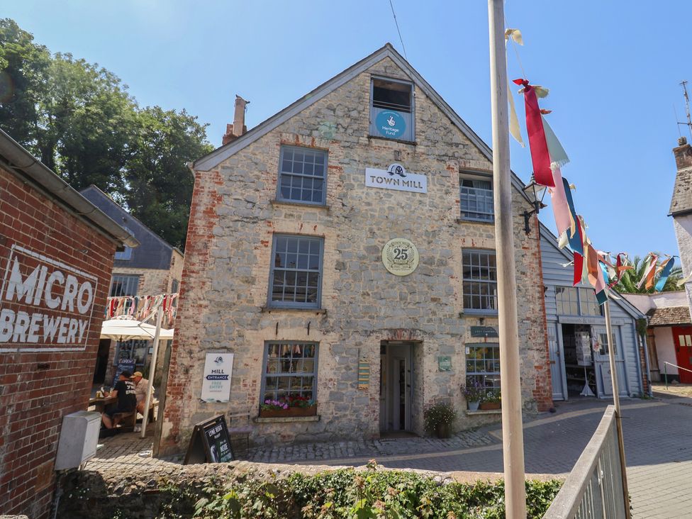 An outdoor area with a building and seating at the Town Mill in Lyme Regis
