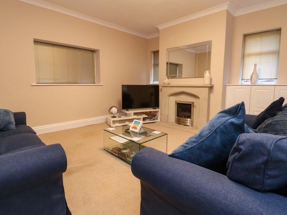 A living room with a TV and sofa at 6D Clifton Drive in Lytham St. Annes