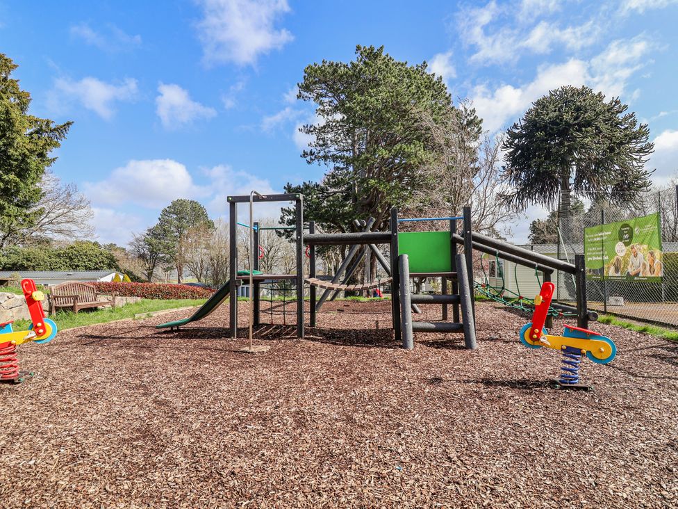 A playground with a climbing frame and slide at Woodlands Retreat in Llanfwrog near Ruthin